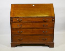 A Georgian mahogany bureau, the fall front with fitted interior over four long drawers with brass