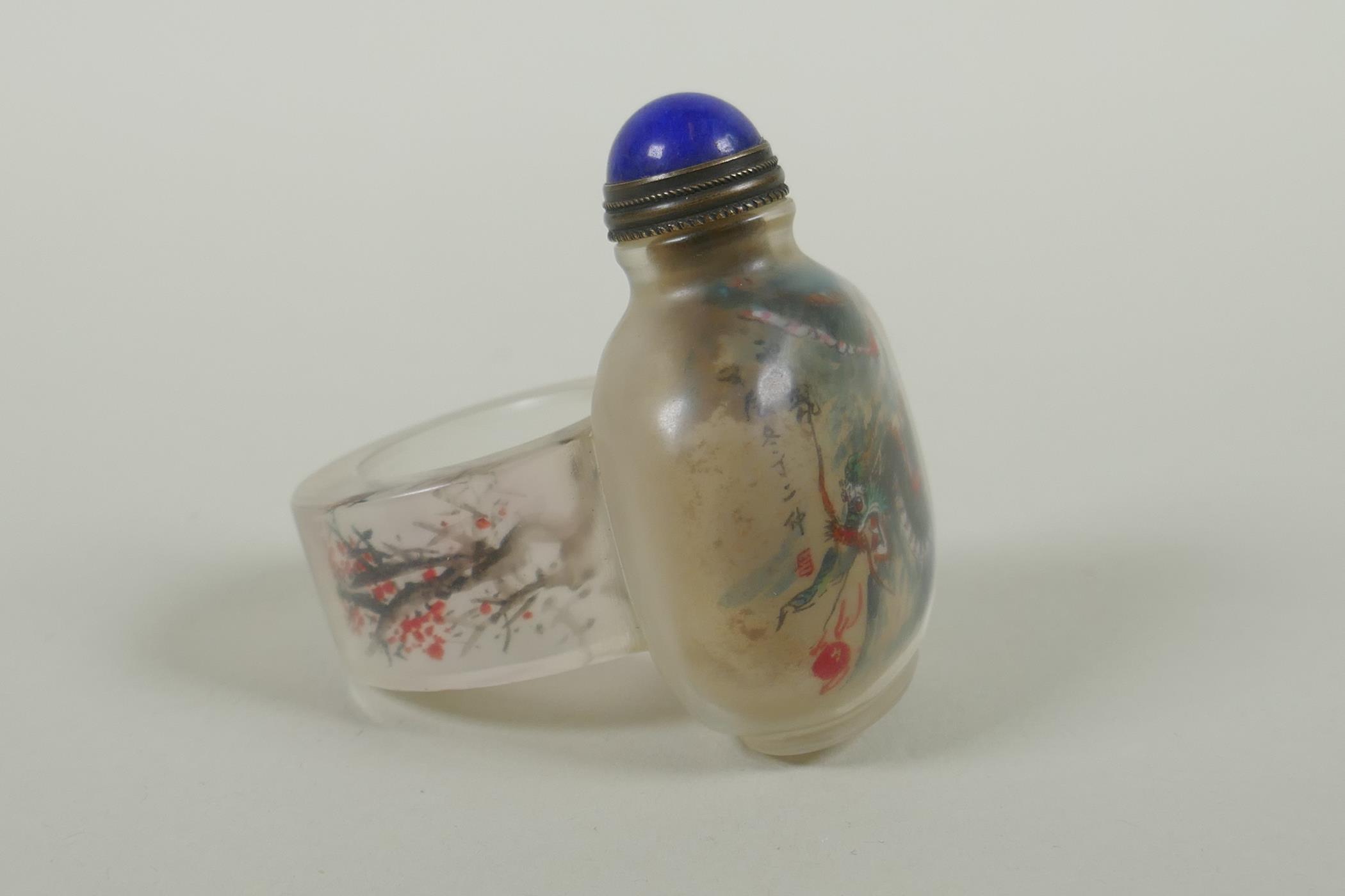 A Chinese reverse decorated glass snuff bottle on a ring, decorated with a green dragon and a red - Image 2 of 4