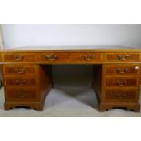 A Georgian style mahogany pedestal partner's desk, with nine drawers and two cupboards, brass swan