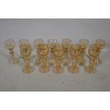 A set of seven C19th amber coloured Hock wine glasses, and five more similar with etched grape and