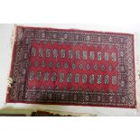 A Bokhara hand woven wool rug, red ground with traditional pattern, 7 x 157cm