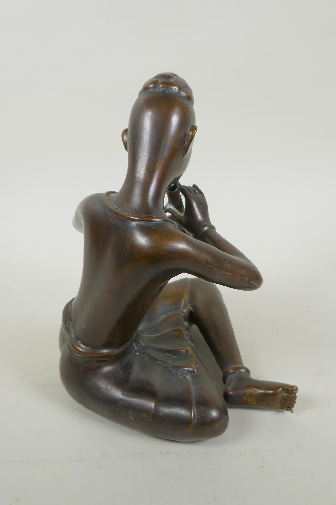 A Thai filled bronze figure of a musician playing the flute, 23cm high - Image 3 of 4