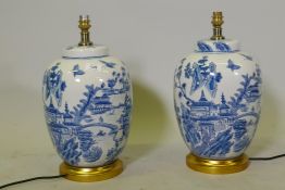 A pair of oriental ceramic table lamps with typical blue and white decoration, mounted on giltwood