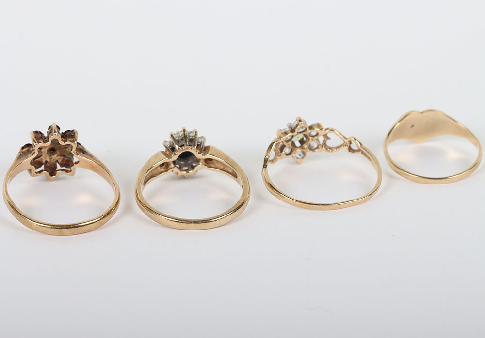 A group of four 9ct rings, including a 9ct ruby flower set ring, with a peridot and diamond ring, a - Image 4 of 6