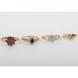 A group of four 9ct rings, including a 9ct ruby flower set ring, with a peridot and diamond ring, a