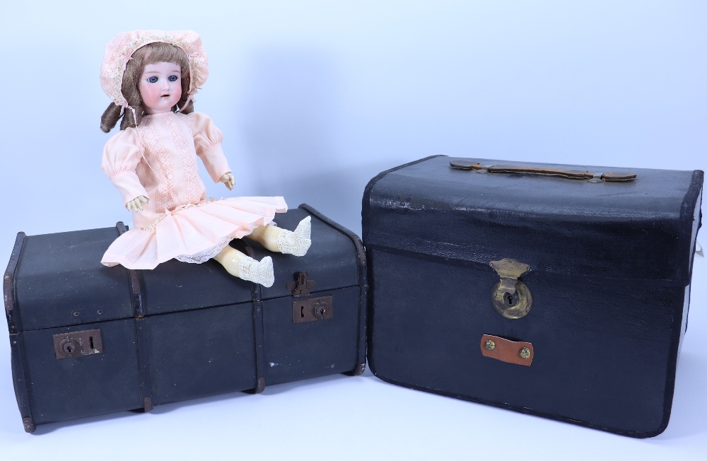 An A.M ‘Floradora bisque head doll in trunk with selection of clothes,