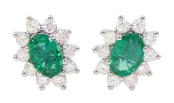 Pair of 18ct white gold oval cut emerald and round brilliant cut diamond stud earrings