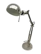 Adjustable chrome desk lamp upon a circular base