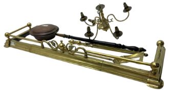 Brass fire fender with scrolled floral decoration (W140cm D43cm); brass fire tools