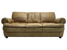 Large three-seat sofa upholstered in stitched brown leather with stud work decoration