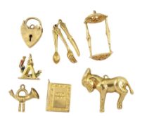 Seven 9ct gold pendant / charms including horn