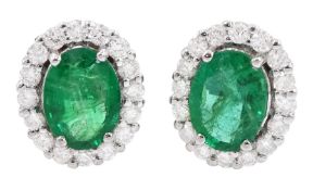 Pair of 18ct white gold oval cut emerald and round brilliant cut diamond stud earrings