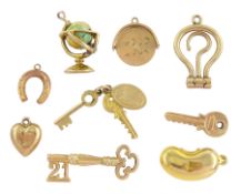Nine 9ct gold pendant / charms including enamel globe by Georg Jensen