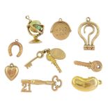 Nine 9ct gold pendant / charms including enamel globe by Georg Jensen