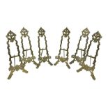 Set of six ornate cast brass easel stands