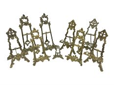 Nine ornate cast brass easel stands of various sizes