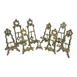 Nine ornate cast brass easel stands of various sizes