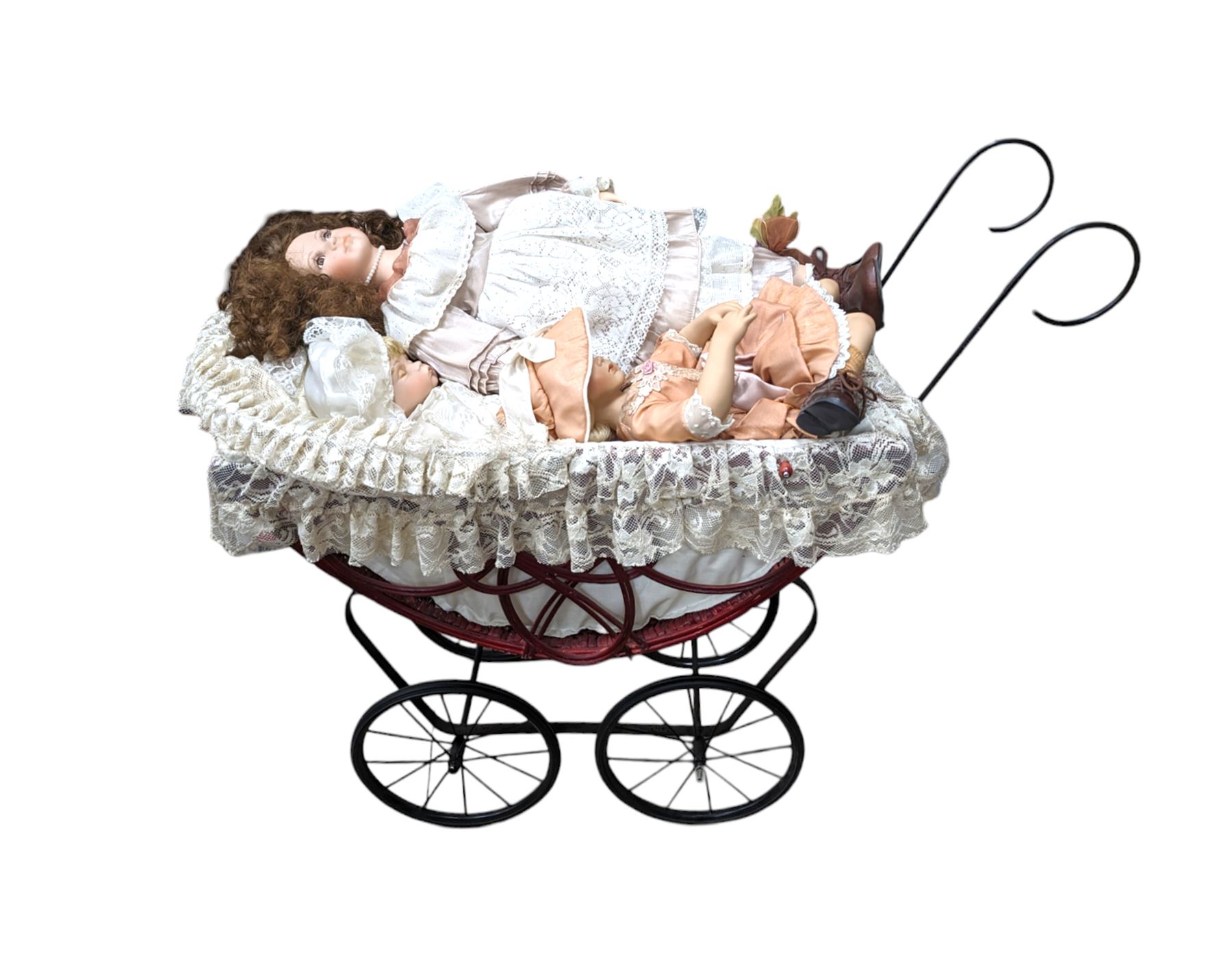Three porcelain dolls and a wicker dolls pram with lace cover