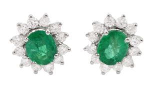 Pair of 18ct white gold oval cut emerald and round brilliant cut diamond stud earrings