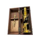 Small brass students microscope in a mahogany fitted box