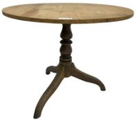 Early 19th century pine and elm tripod table; circular tilt-top over turned column and three splayed