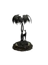 Sculpture of a giraffe under a palm tree upon a mirrored base