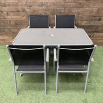 Rectangular metal framed garden table with glass top and four stackable chairs