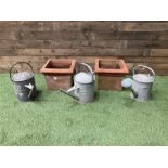 Galvanised watering cans and terracotta plant pots