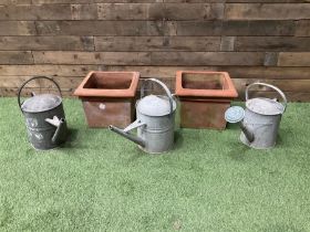 Galvanised watering cans and terracotta plant pots