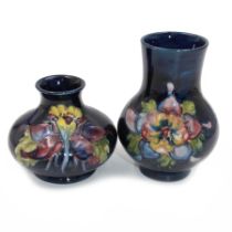 Two small Moorcroft vases decorated in Columbine pattern on dark blue ground