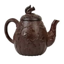 A brown/red stoneware small teapot.