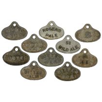 A group of ten cast metal cellar beer labels.