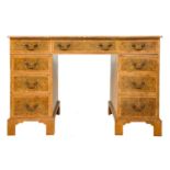 A 20th century figured yew pedestal desk by Abbey Reproductions, Penzance.