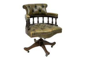 A button backed green leather captain's swivel chair.