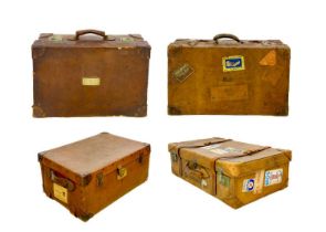 Four leather travel trunks in various sizes.