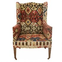 An early 20th century Kelim upholstered wingback armchair.