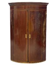 A George III mahogany bow front hanging corner cupboard.