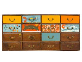 A bank of 16 late Victorian stained and later painted pine drawers.