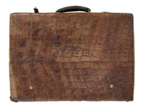 A good quality crocodile skin and brass bound suitcase.