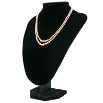 A double-strand graduated cultured pearl necklace with three-stone diamond clasp.