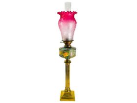 A Victorian cranberry shade brass oil lamp.