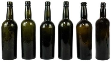 Six assorted green glass wine bottles.