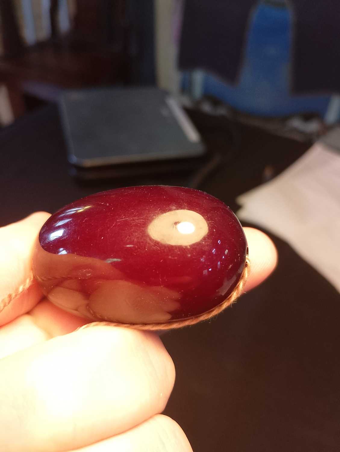 A large bakelite cherry amber bead,. - Image 7 of 7