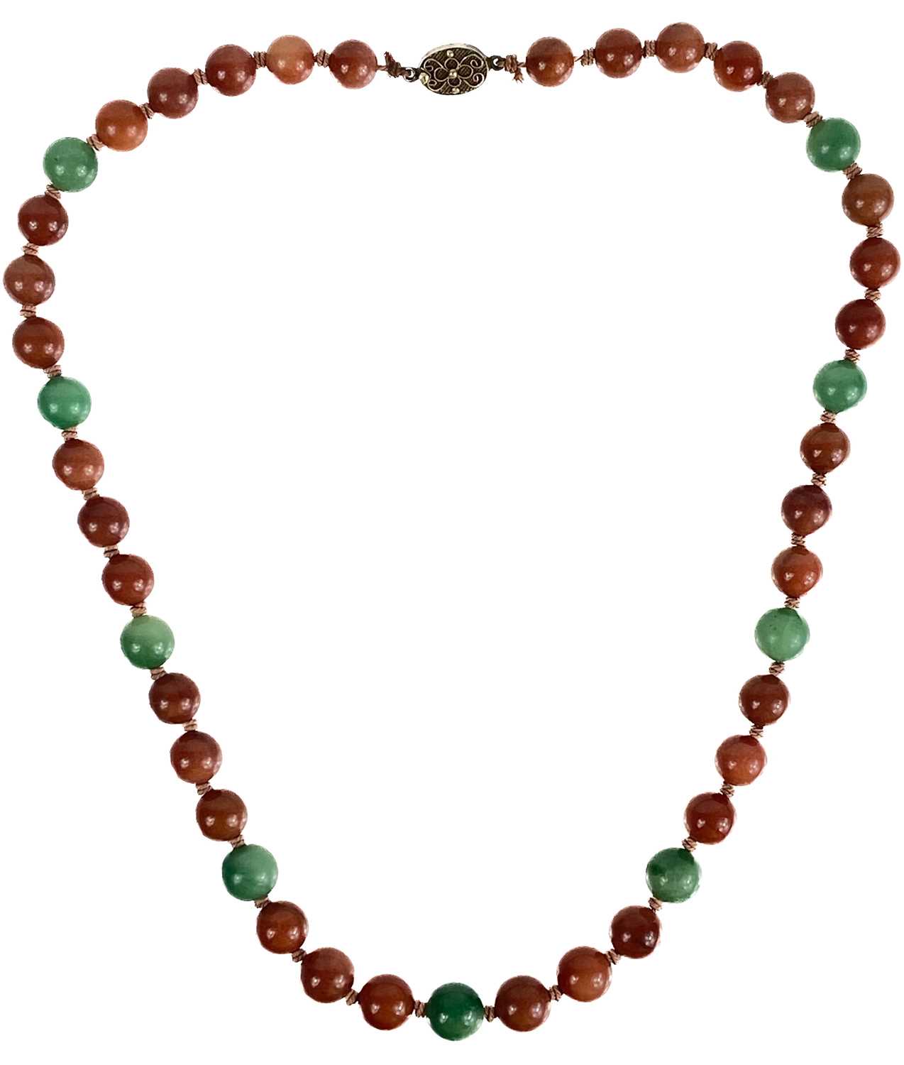 A Chinese green and russet jade bead necklace with silver filigree clasp.