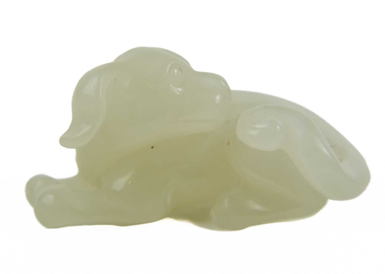 A Chinese jade model of a reclining dog, late Qing Dynasty.