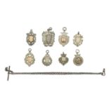 A selection of eight silver shield watch fobs and a silver Albert watch chain.