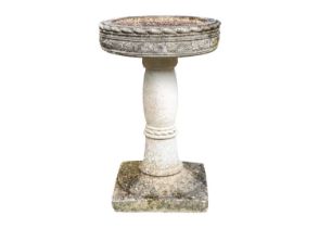 A reconstituted stone bird bath of circular form, on square base.