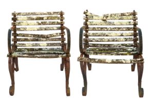 A pair of wrought metal and slatted wood garden chairs.