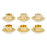 A set of six gilt decorated coffee cans and saucers.