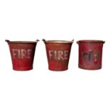 Three red painted metal 'FIRE' buckets.